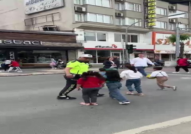 Trafik polisi trafiği kesti, çocukları karşıdan karşıya geçirdi