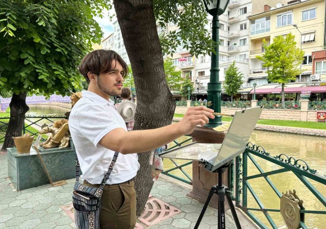 İlk kez geldiği şehrin sokaklarını gezerken sulu boya ile resmediyor