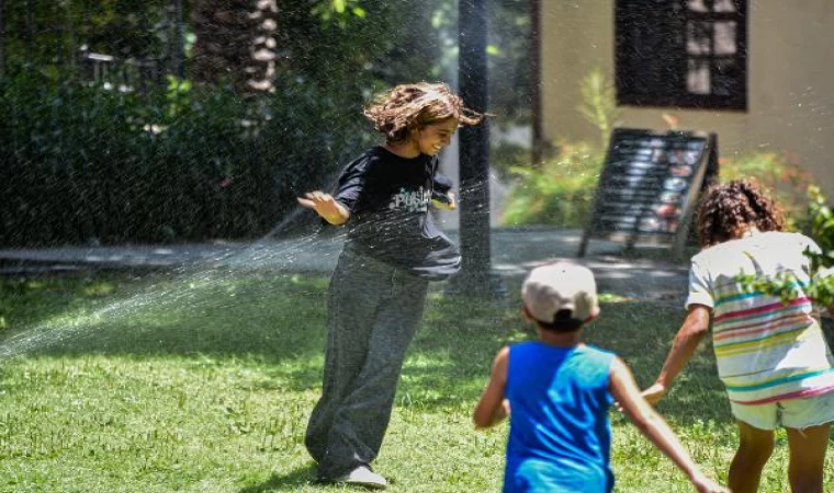 Antalya’da sıcaktan bunalanlar fıskiye ile serinledi, turistler gezerken şemsiye ve şapka kullandı