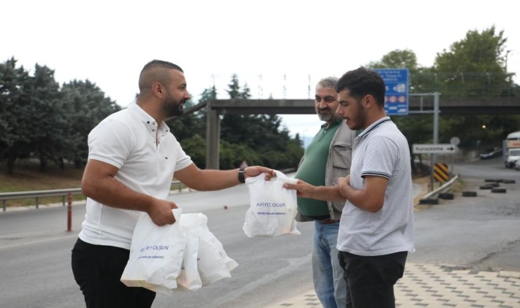 Servis bekleyen işçilere poğaça dağıtılıyor