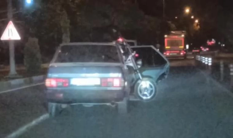 Otomobilin arka koltuğunda taşıdığı motosikletin ön tekeri dışarıda kaldı