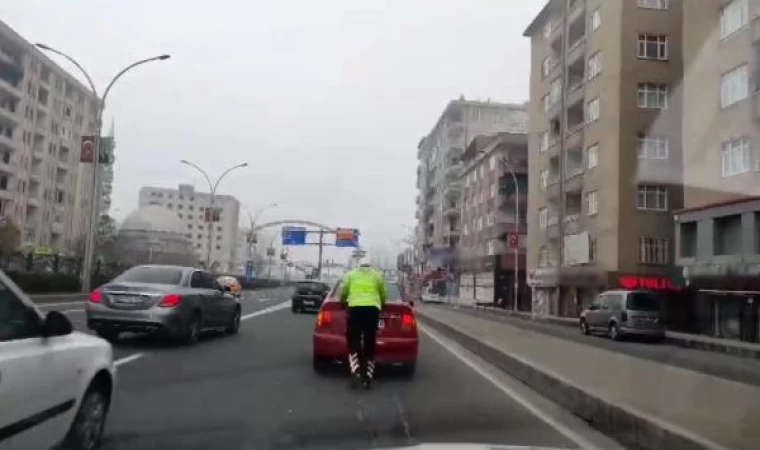 Trafik polisi, yakıtı biten otomobili 2 kilometre iterek, akaryakıt istasyonuna götürdü