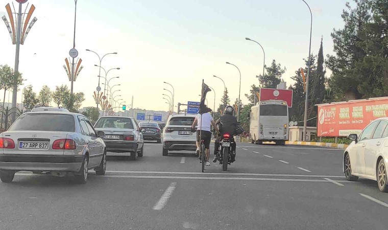 Motosiklete tutunan bisikletlinin tehlikeli yolculuğu kameraya yansıdı