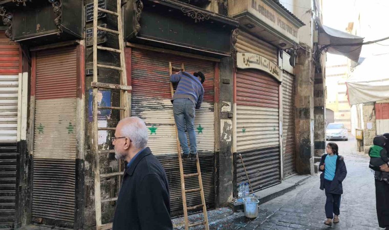 Esnaflar kepenklerindeki eski Suriye bayraklarını kazımaya başladı