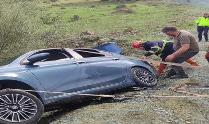 Otomobil yol kenarında asılı kaldı, araçtaki çift ölümden döndü